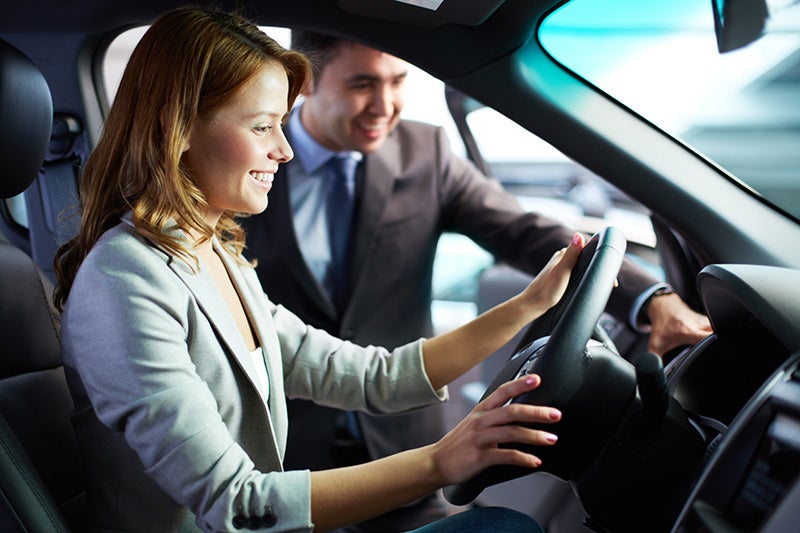 salesman helping woman looking at a vehicle
